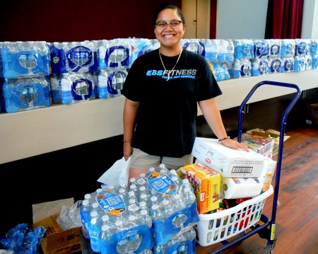 Student receiving food, water, and clothing after her house was destroyed.